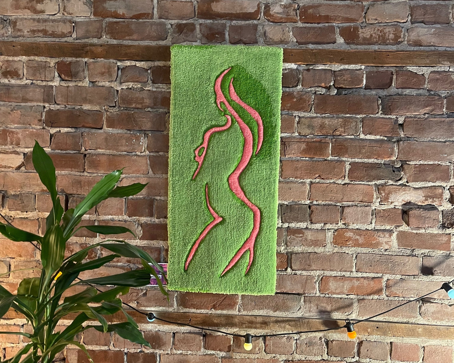 Œuvre textile colorée mêlant rose doux et vert intense pour une ambiance organique et apaisante.