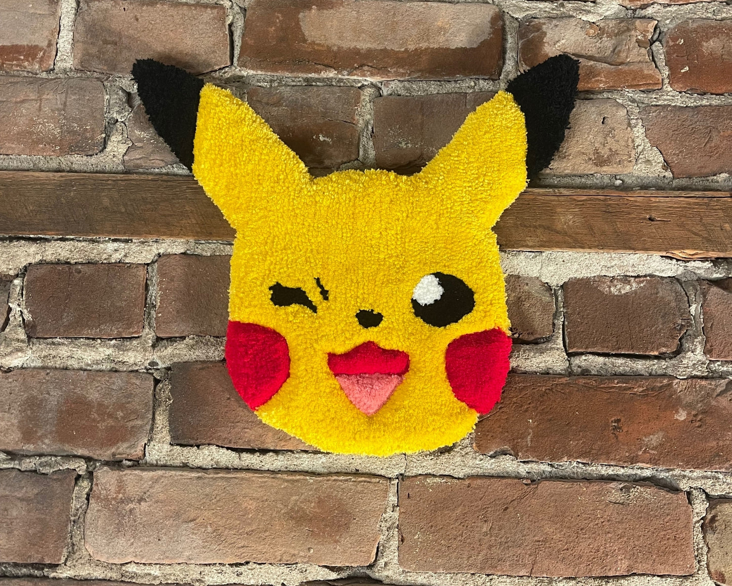 Tapis fait main fabriqué avec la technique de tissage du tufting qui reprend le design de pikachu de pokemon