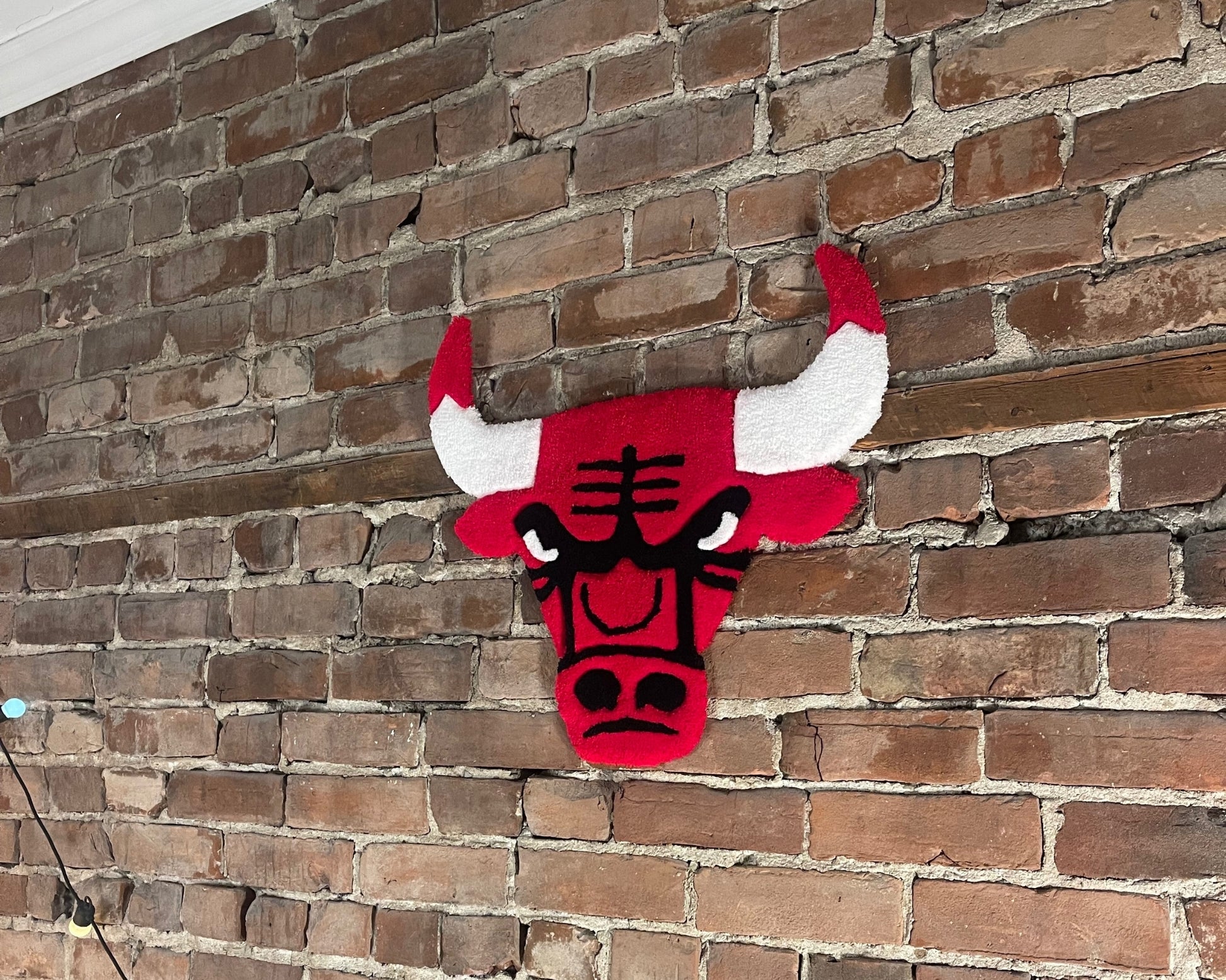 Tapis mural décoratif symbolisant le logo des Chicago Bulls fait main.