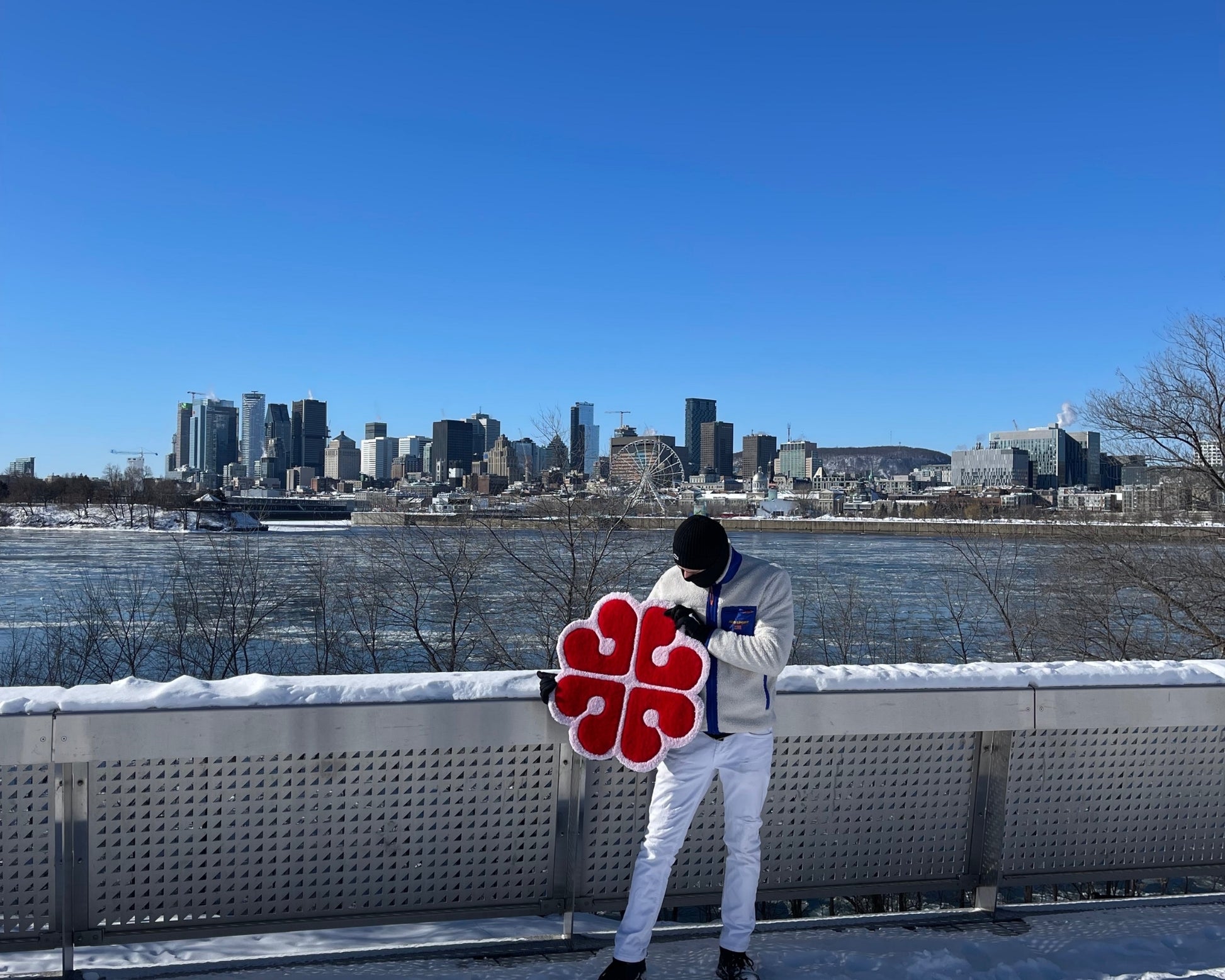 Tapis décoratif unique fait à la main représentant le logo de Montréal au Canada. La photo prise offre une vue en arrière plan sur la ville de Montréal. 