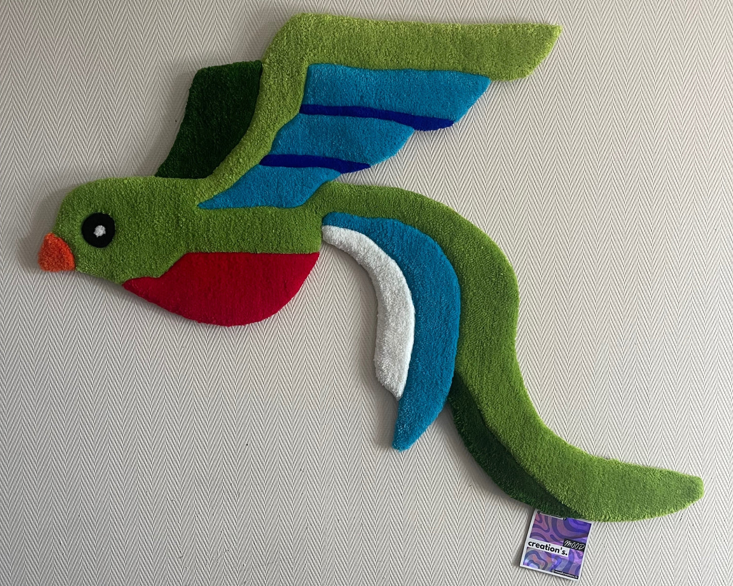 Œuvre textile unique inspirée du quetzal, tufting artisanal et design engagé.