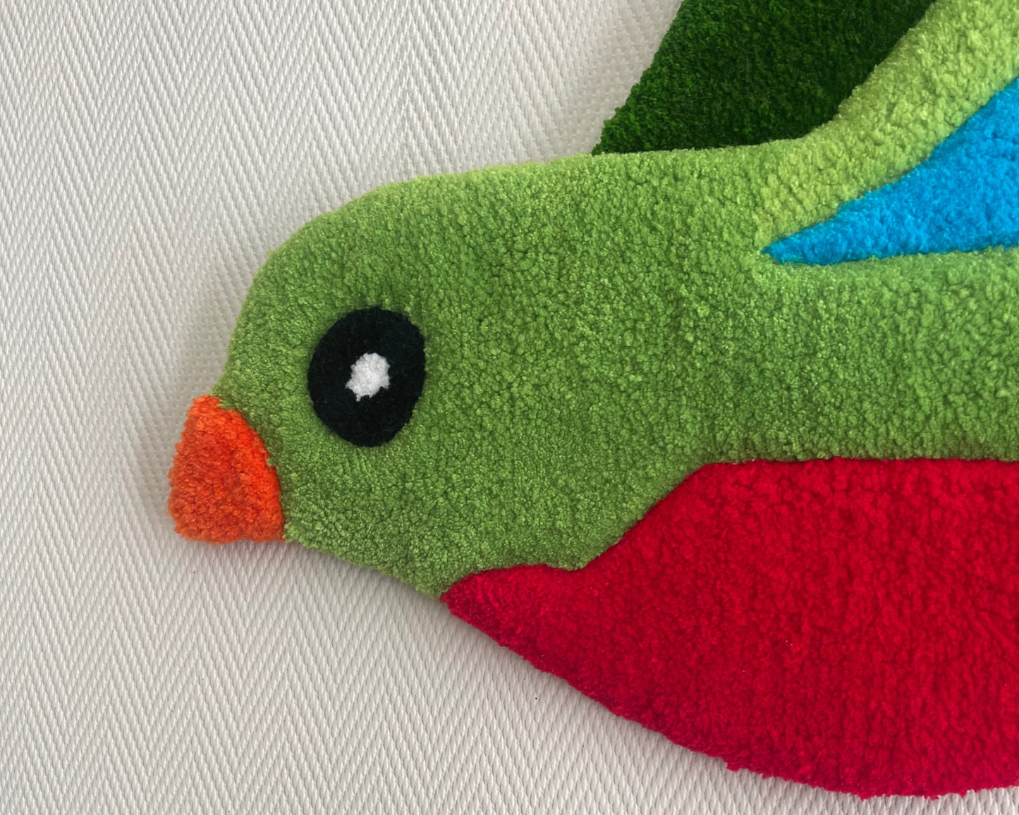 Gros plan couleurs, nuances et reliefs tissés à la main sur l’œuvre Quetzal.