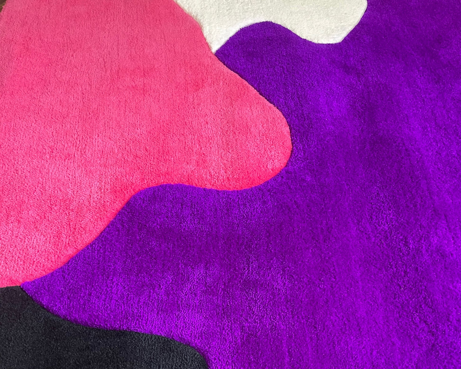 Création textile contemporaine tuftée à la main. Un tapis de salon hypnotique aux formes vibrantes.