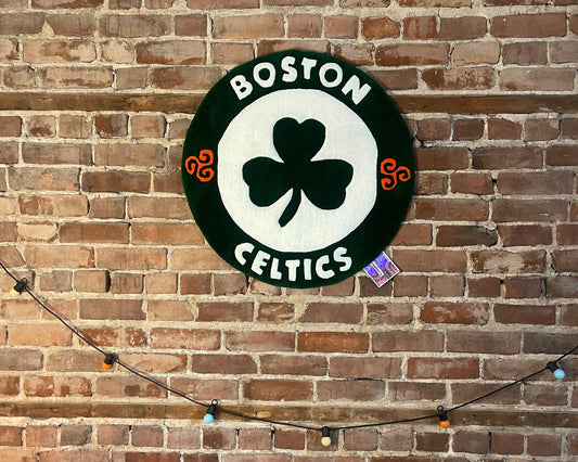 Photo en situation du tapis Celtics exposé dans un intérieur moderne, soulignant son style graphique et son ancrage culturel.