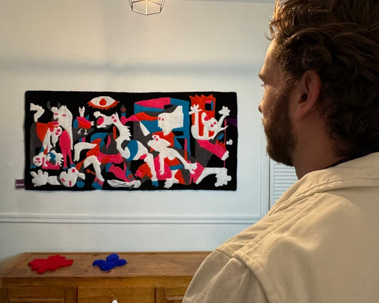 Œuvre textile engagée en laine tuftée. Tapis mural artistique représentant Guernica de Pablo Picasso revisté à travers des couleurs vives. 