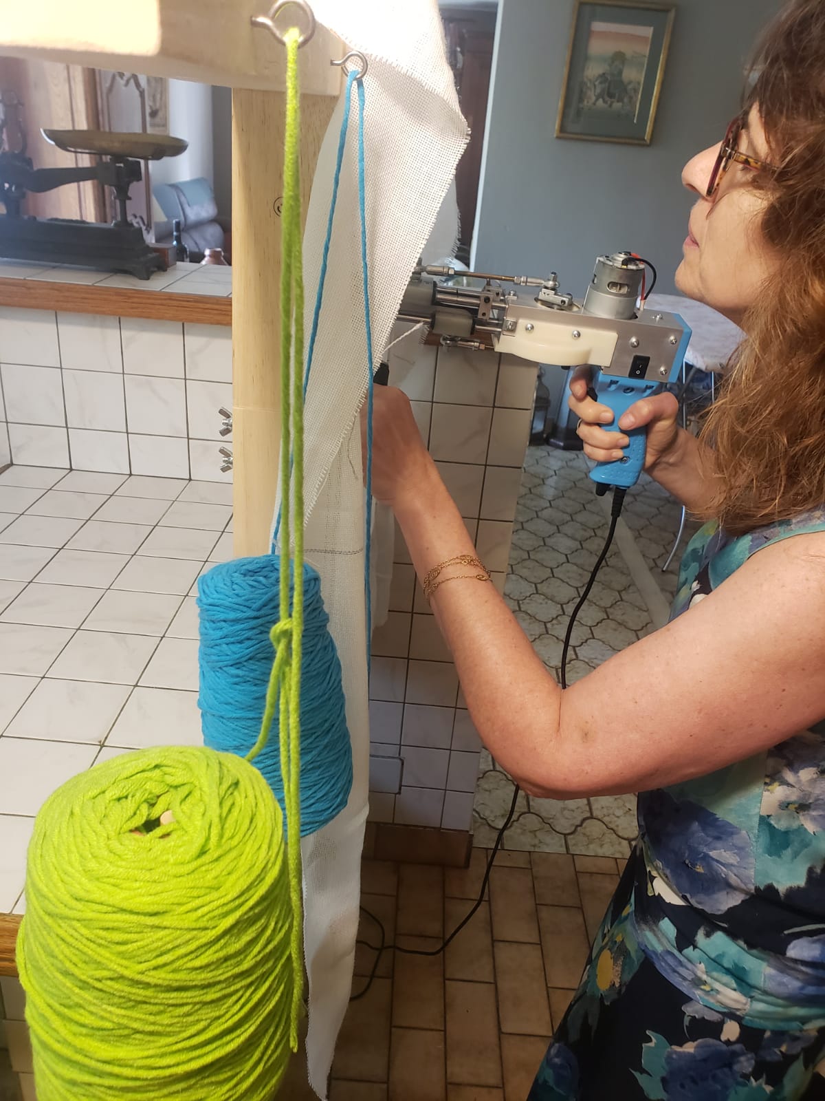 Une dame réalise son tapis tufté lors d'une initaition.